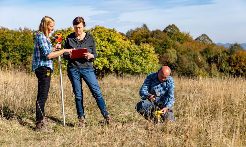 Surveying team marking property boundaries and recording data during a boundary line survey