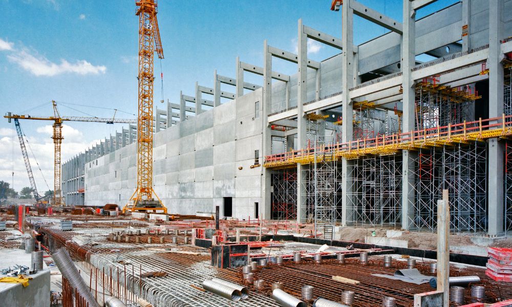 Commercial retail construction site with cranes and concrete framework, showing why an ALTA Land Title Survey is essential before development

