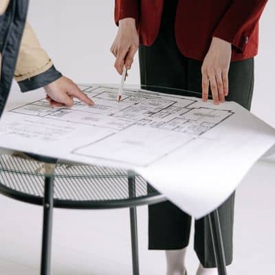 Survey professionals reviewing official boundary plans during a property line survey to confirm legal property limits