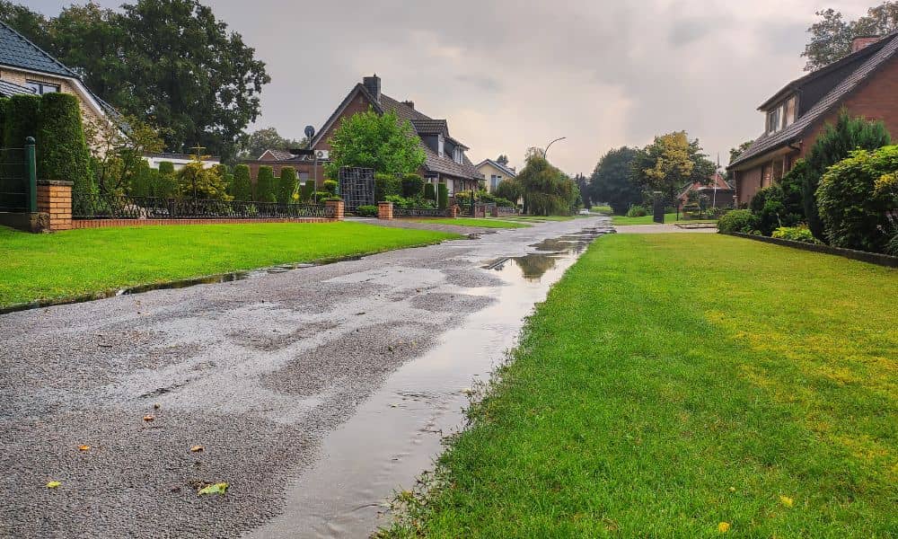 Residential street with standing water after heavy rain, showing why an elevation certificate matters for flood insurance