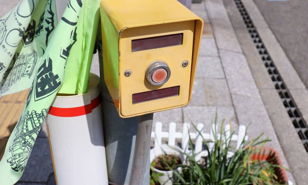 Crosswalk button at an intersection designed by a transportation engineer to help pedestrians safely cross the street