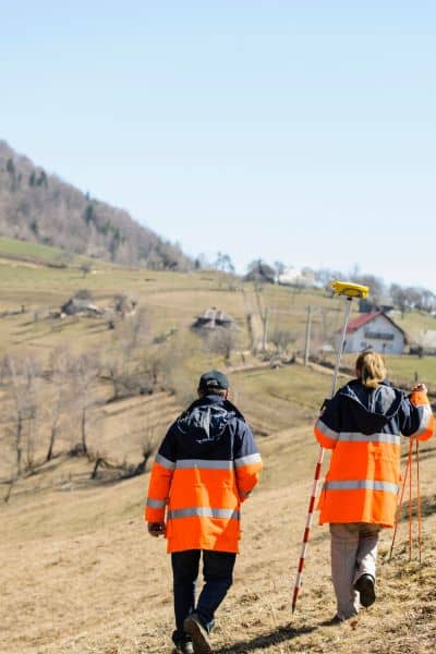 Land surveyors working with gps equipment in field - ALTA SURVEY Dallas Surveyors using GPS equipment while working on a property
